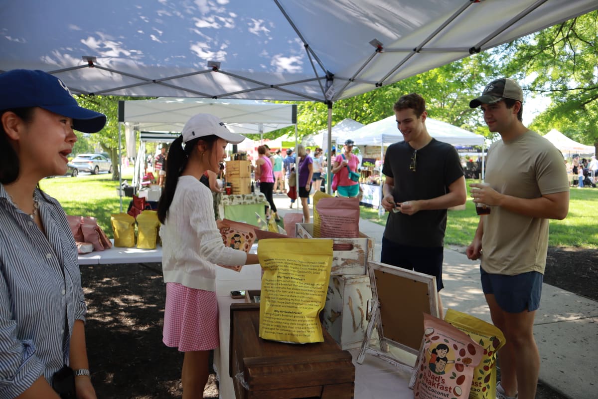 Customers sampling Dad's Breakfast granola at a farmers market